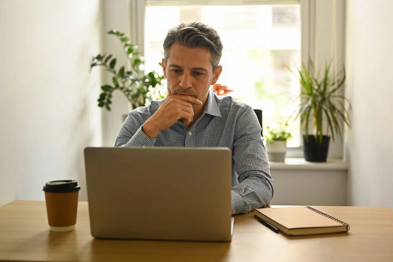 Independent consultant reviewing work on a laptop in their office