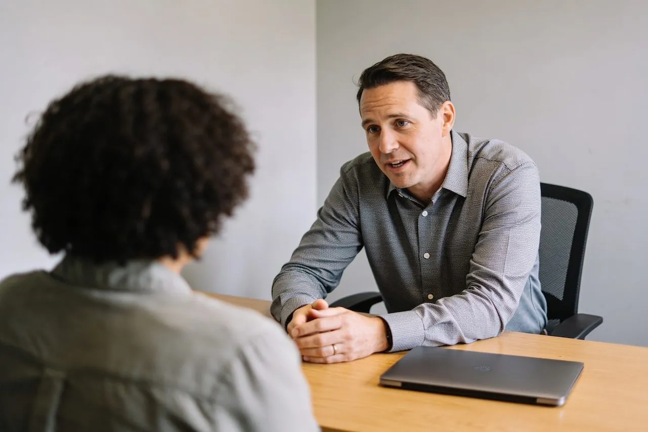 Insurance agency owner meeting with a client at their office desk