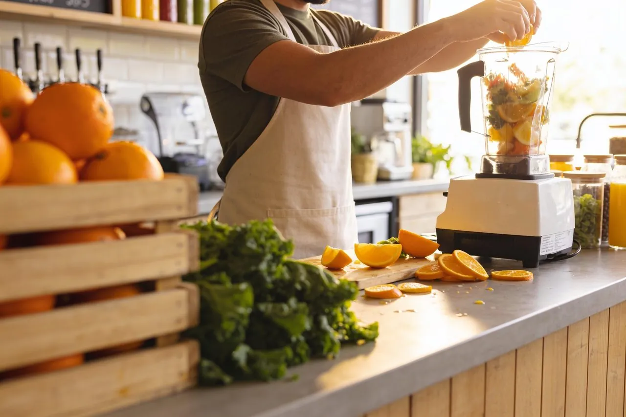 Juice bar owner blending fresh fruit behind the counter