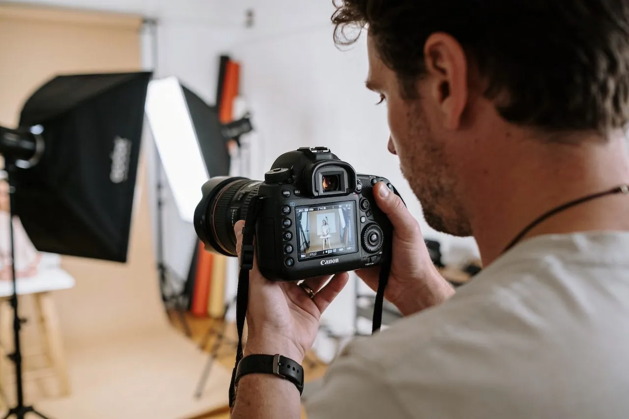 Photographer reviewing shots on a camera in their portrait studio