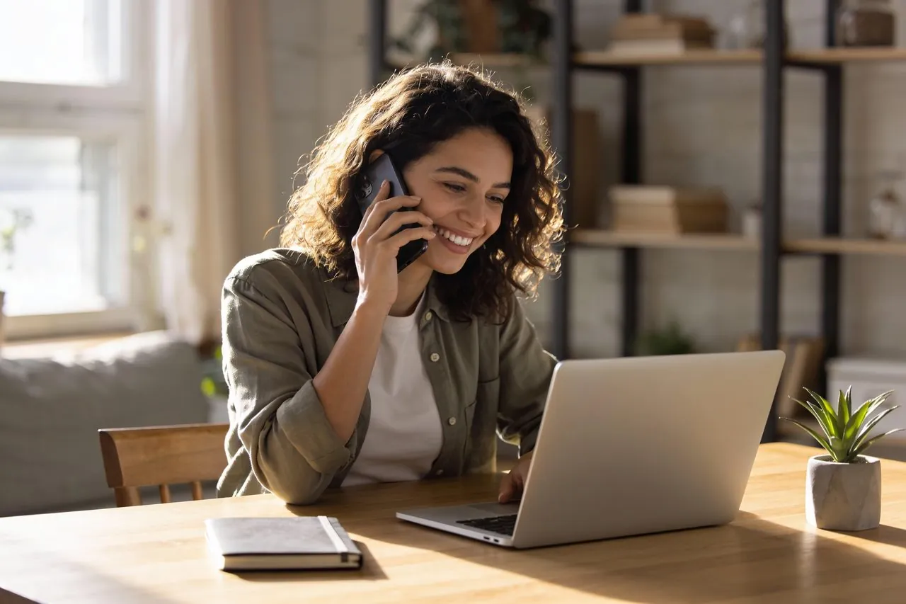 Small business owner following up with a customer by phone at her desk