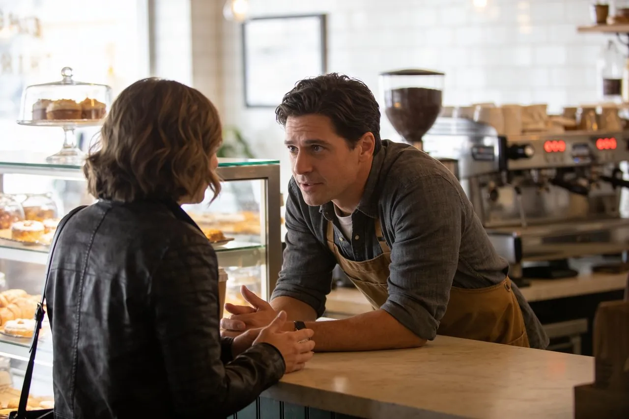 Coffee shop owner listening attentively to a customer at the counter